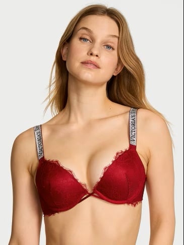 Woman posing in a Victoria's Secret red push-up bra on a light grey background.