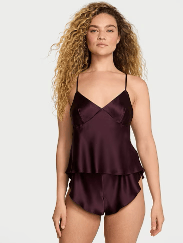 Front view of a woman wearing Victoria's Secret winter wine satin cami and shorts set on a light grey background.