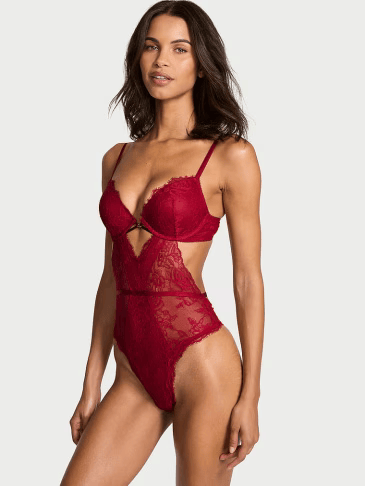 Front view of a woman wearing Victoria's Secret rose lace push-up teddy lingerie on a light grey background.